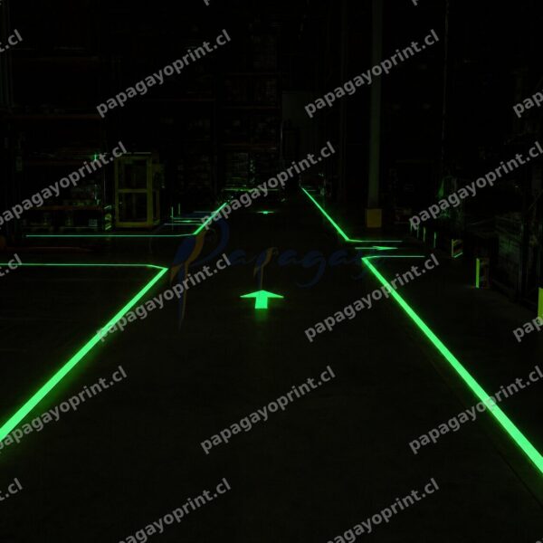 Vinilo fotoluminiscente demarcacion de piso brillando en bodega industrial - Papagayoprint Chile